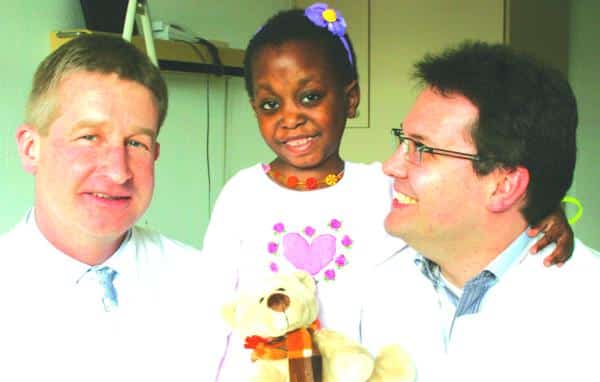 Kinderchirurgie-Chefarzt Dr. Bertram Reingruber (l.) und Assistenzarzt Dr. Markus Dürsch freuen sich, dass sie der kleinen Regina aus Angola mit einer komplizierten Operation helfen konnten.	Foto: pm